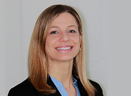 Professional headshot of a Doctor of Occupational Therapy program faculty member with blonde hair, wearing a light blue shirt and black blazer