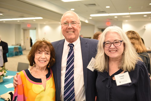 three people pose for the camera