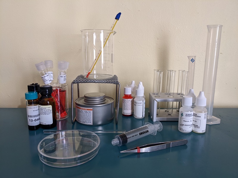 a bunch of lab equipment on a table including glass beakers and jars of liquid