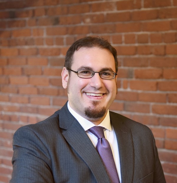 Aaron Hoffman in grey suit and purple tie