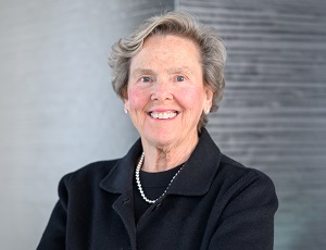 paula wears a dark suit and set of pearls