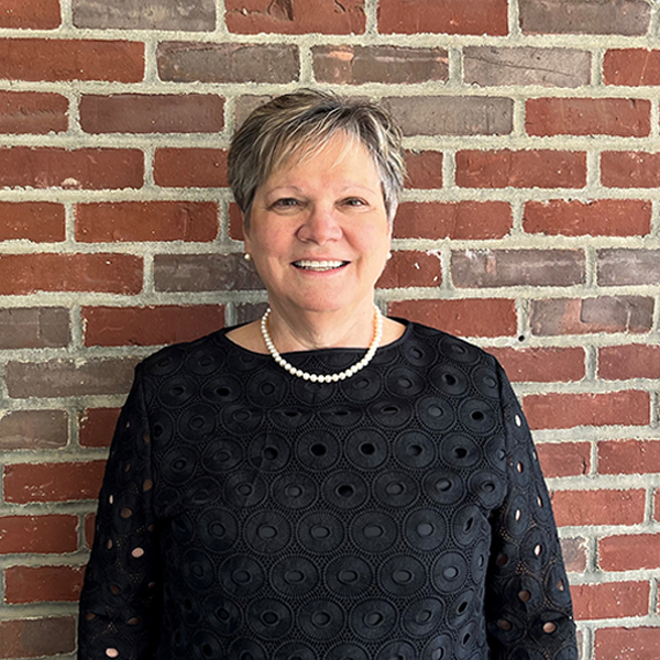 mary stands in front of a brick wall