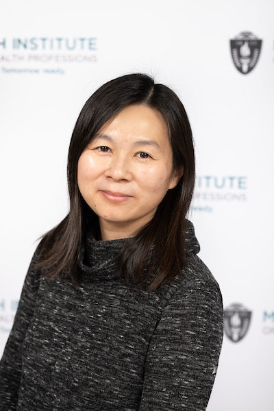 kim has a mottled black cowl neck shirt on and is Asian presenting