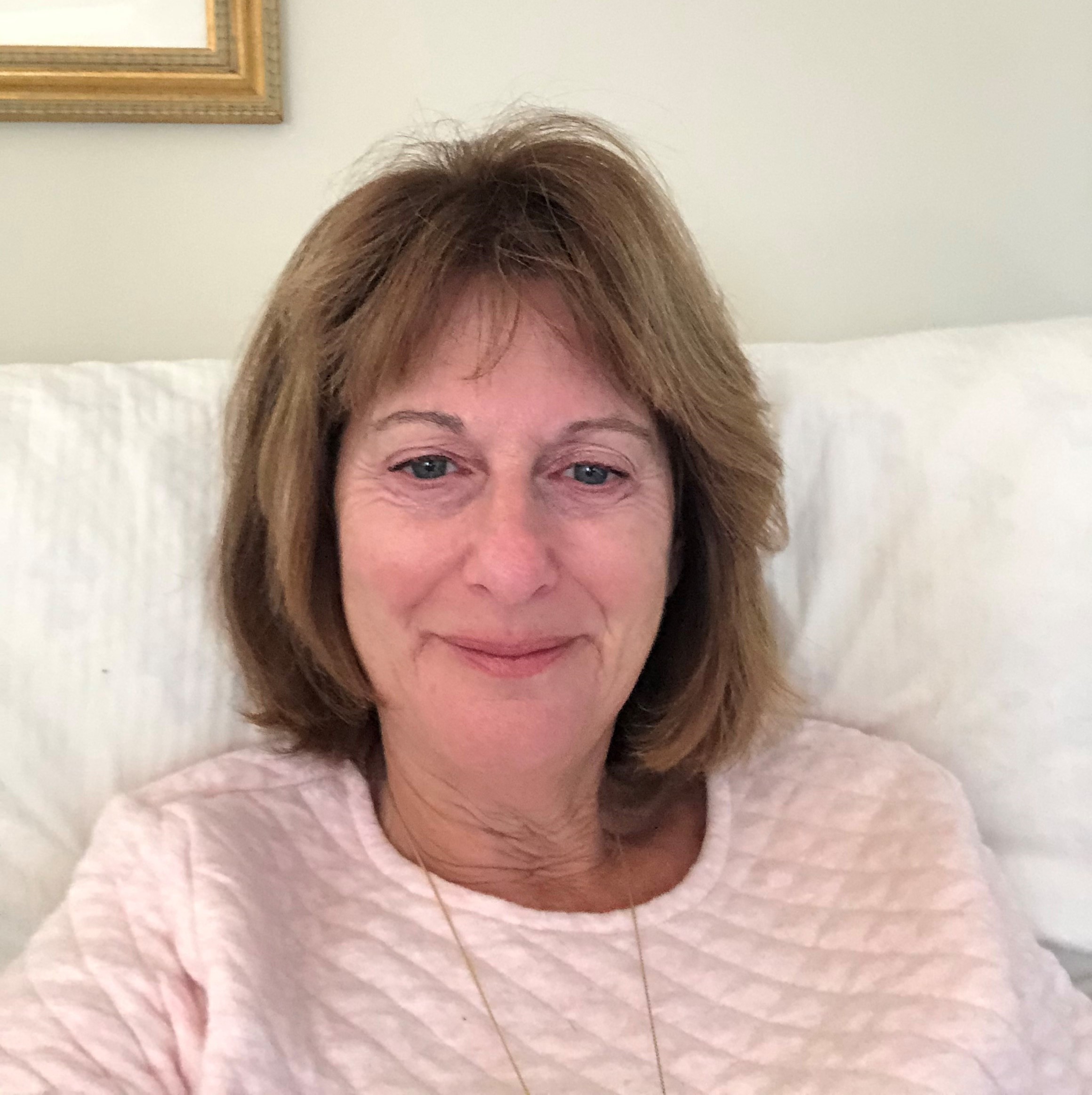 Woman sitting on couch with light pink top