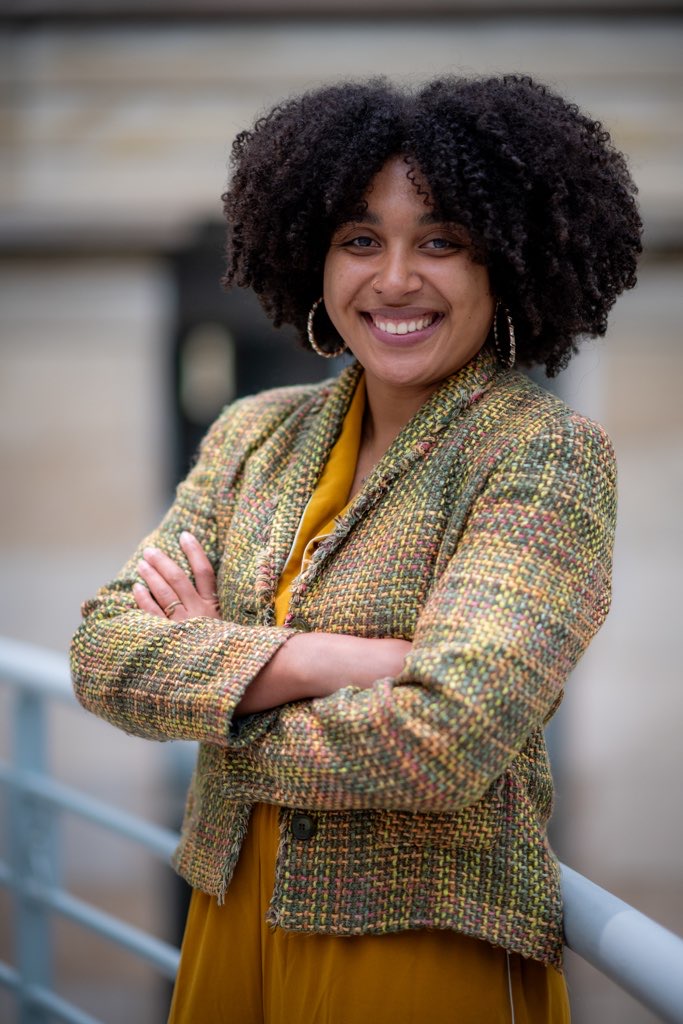 natalie wears her natural curls and gold hoop earrings