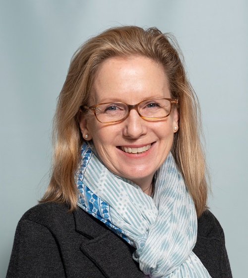 lynne wears a aqua patterned scarf and tortoiseshell glasses