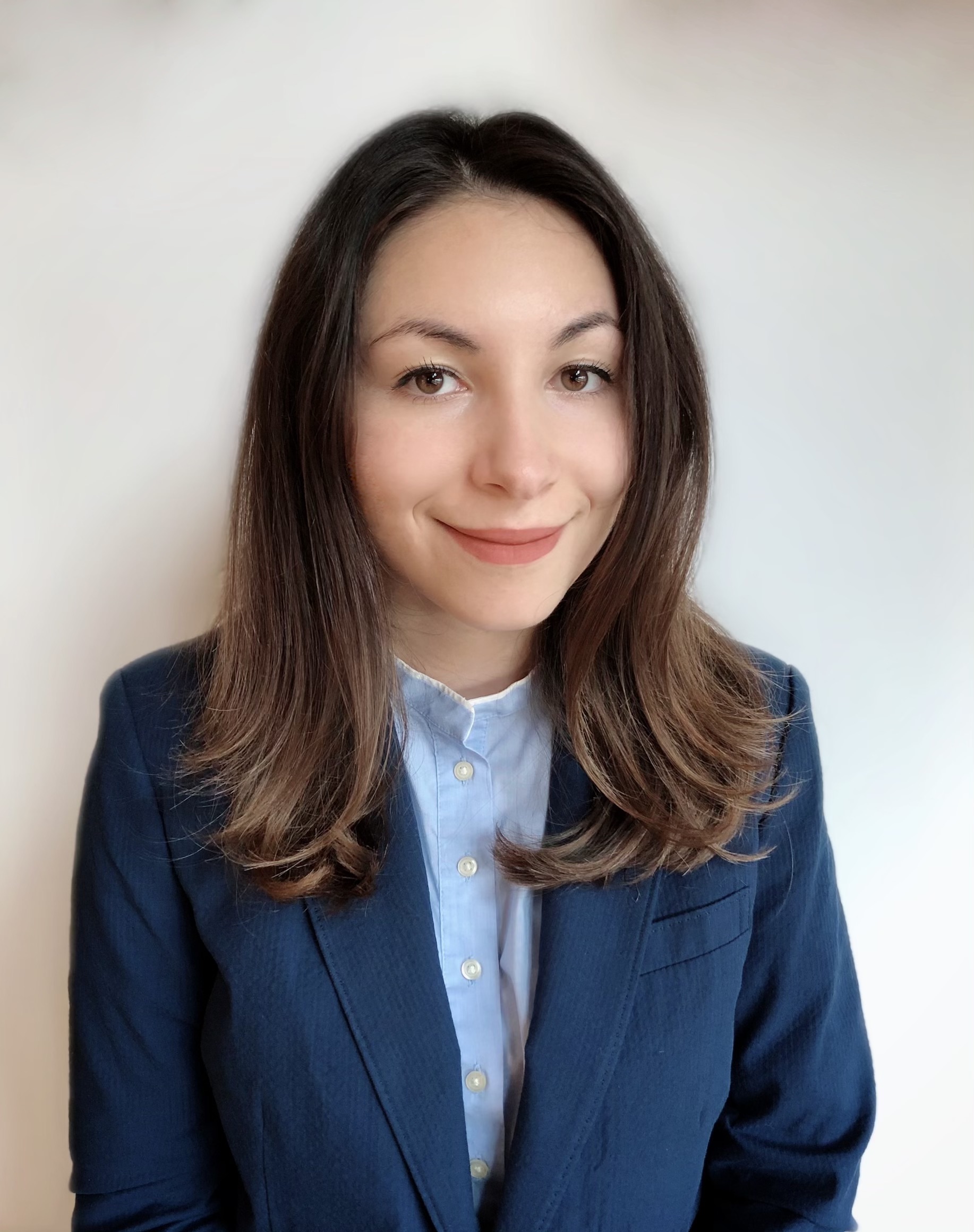 Diana Marchione has medium-length brown hair and brown eyes. She is wearing a navy blazer and light blue button up. 