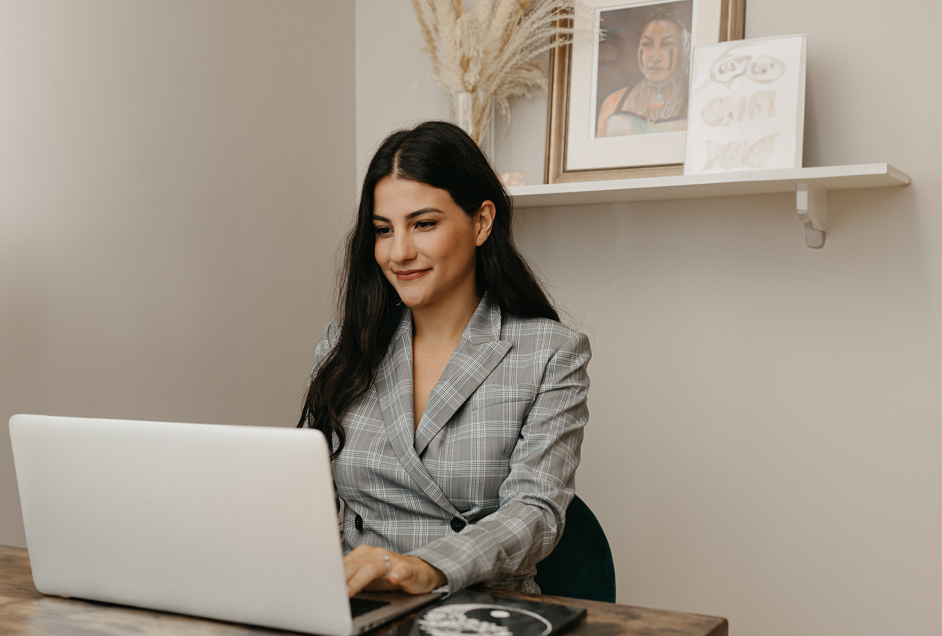 woman at laptop in cream colored room