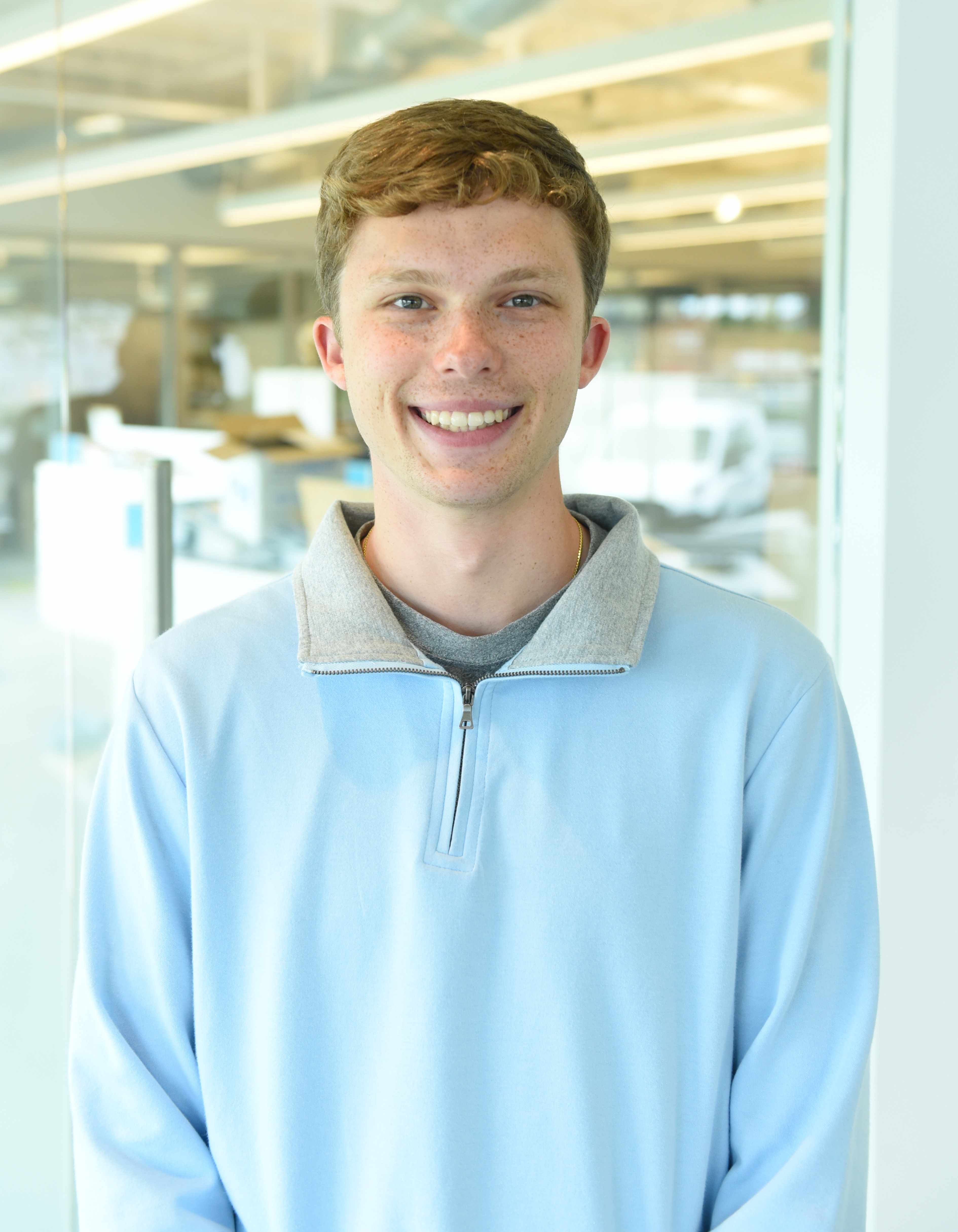 Alex Kaminsky wearing a light blue three-quarter zip up
