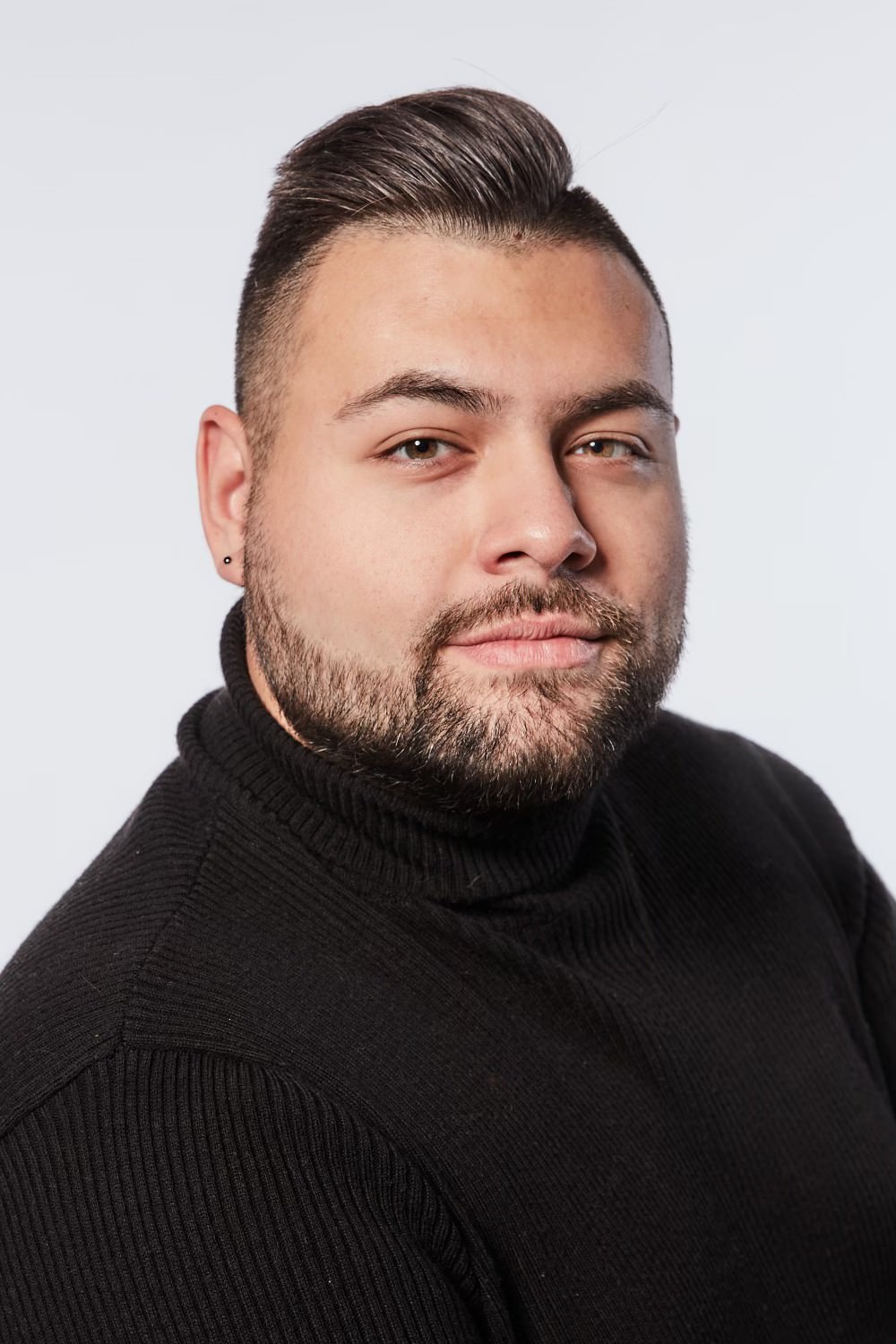 john wears a black turtleneck and has a close cropped beard