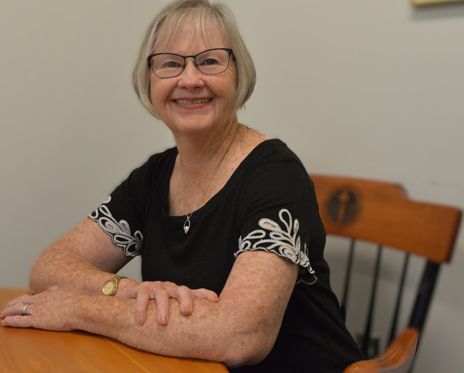 pat wears glasses and a black and white top
