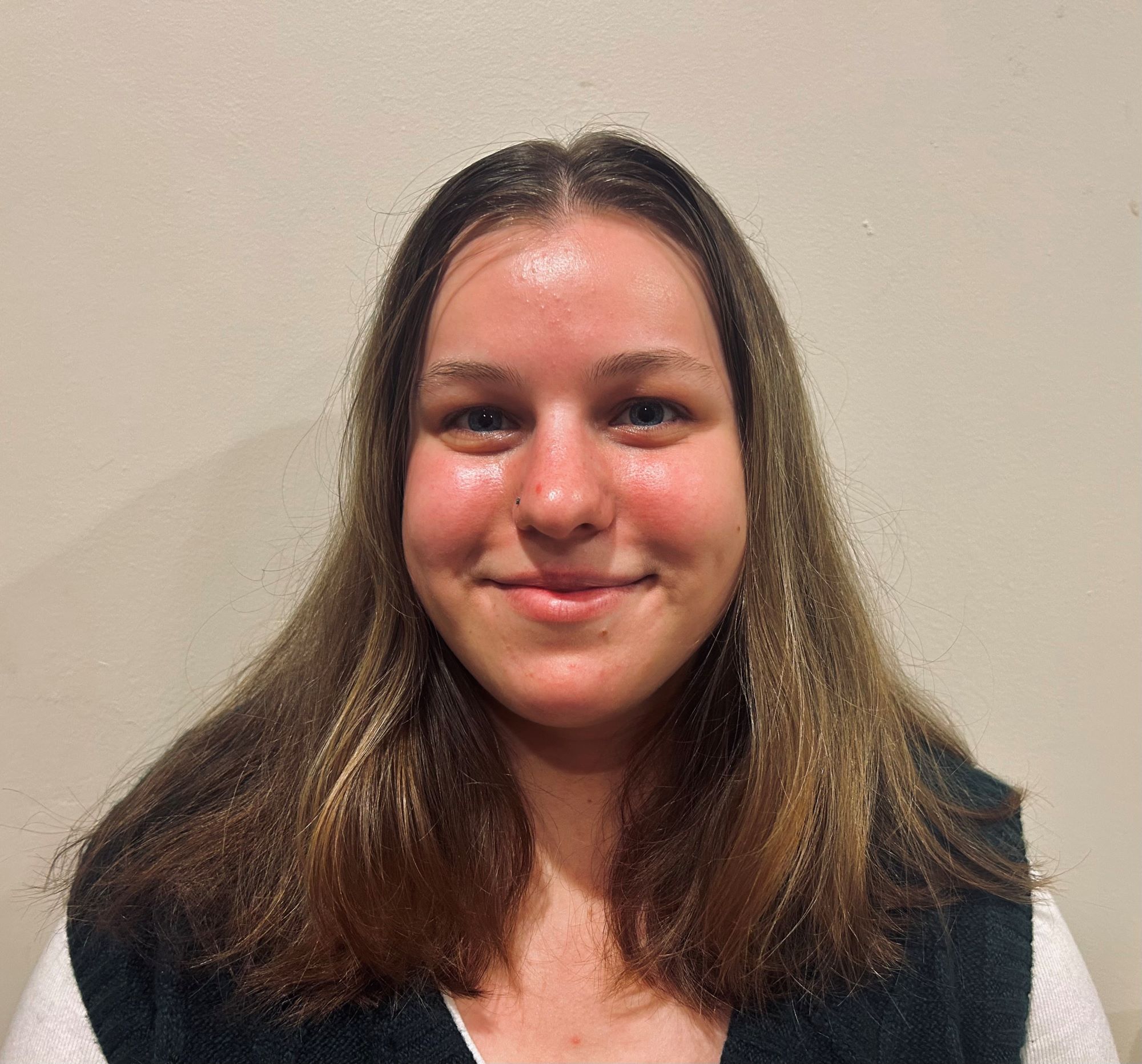 Anna Ziselman has shoulder length brown hair and is wearing a black vest