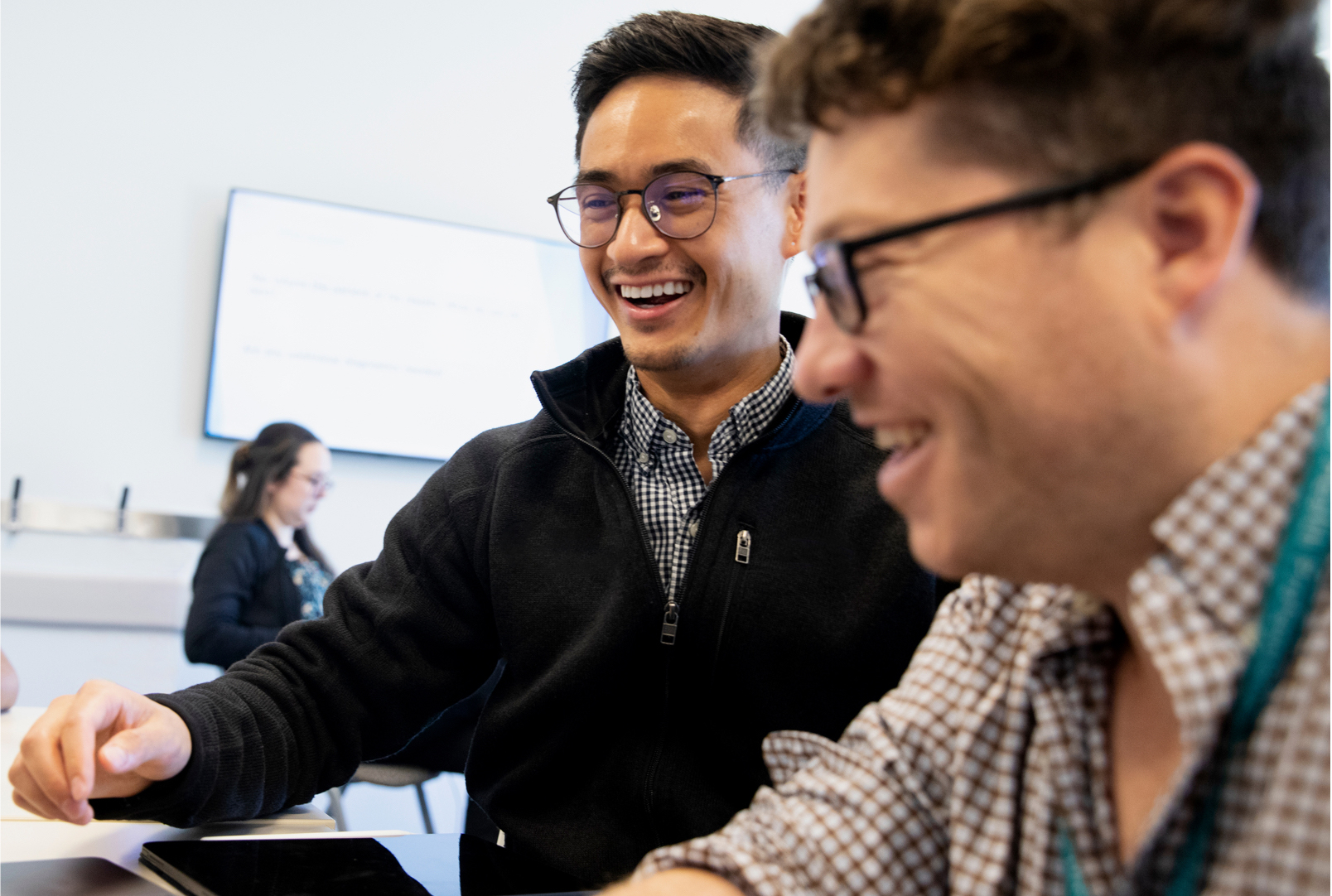 Two students working together and laughing.