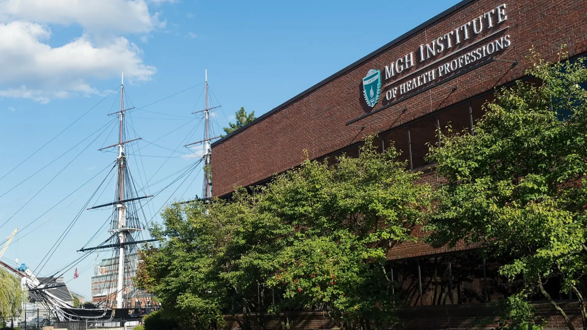 brick building with two mast schooner in the background