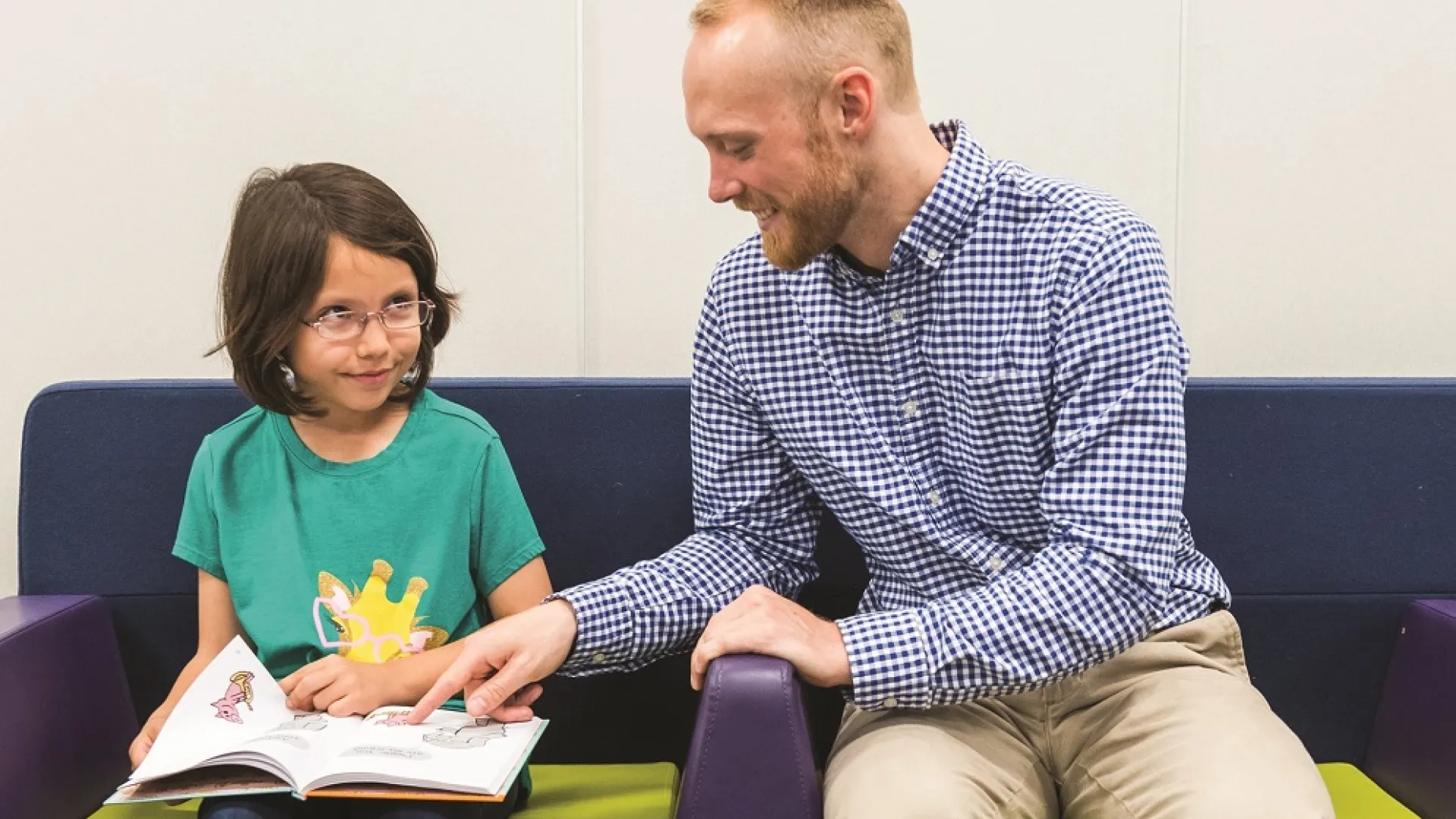 A literacy coach in the Literacy and Language Certificate Program helps a young student with reading comprehension. The program focuses on evidence-based literacy instruction and advanced literacy strategies, preparing educators for reading specialist certification and literacy leadership training.