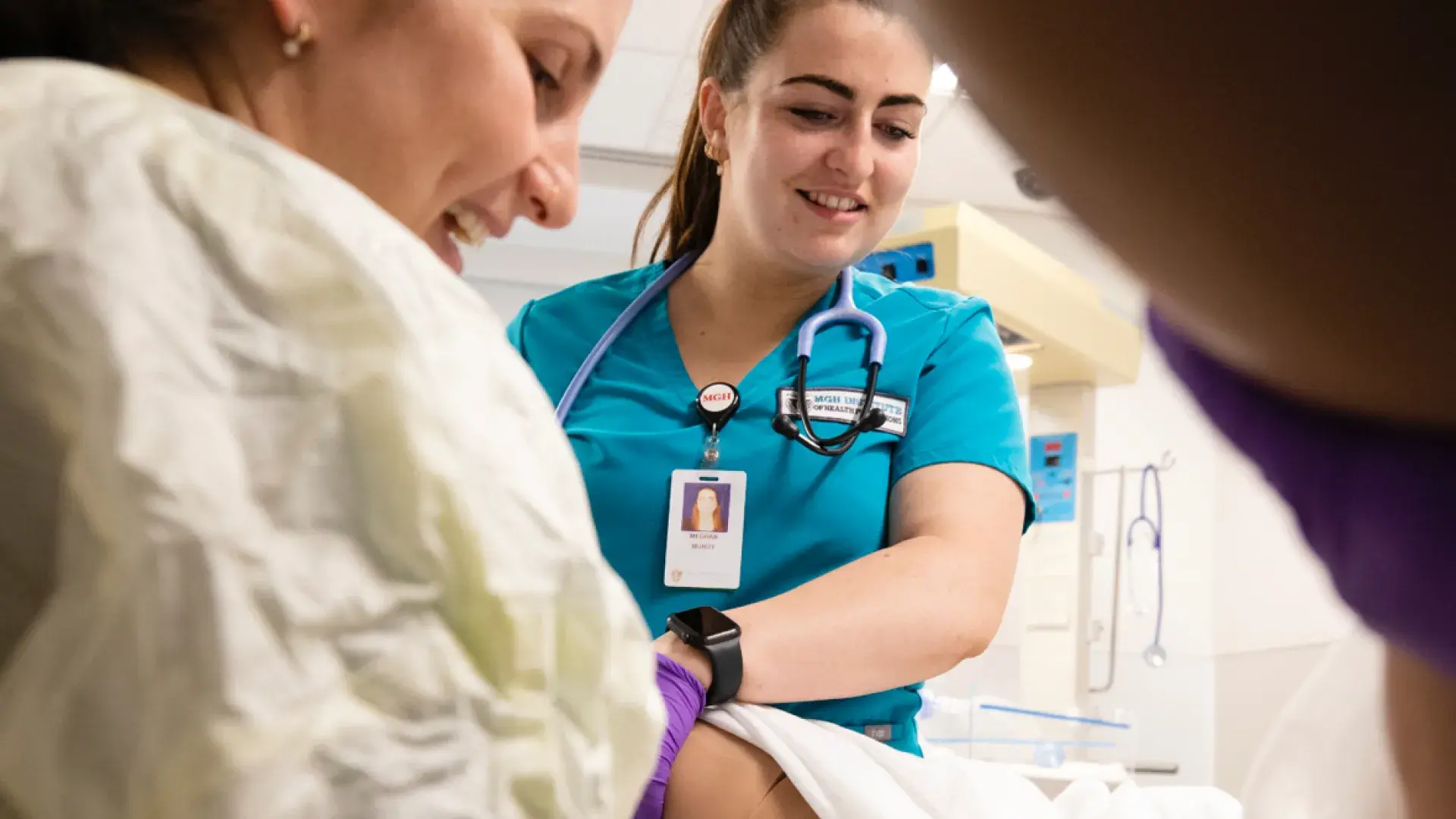 Two nurses wearing scrubs in a hospital room