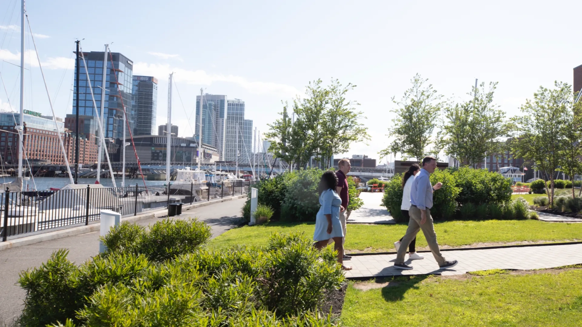 People walking in a park with the waterfront in the background