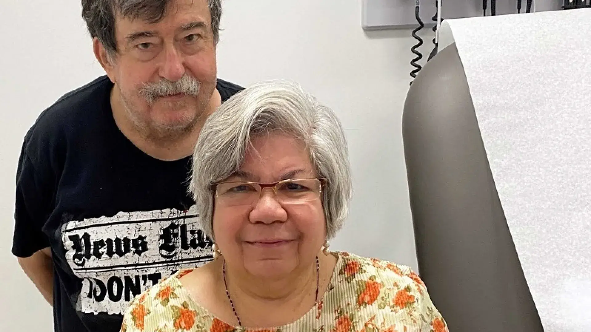 an older man and women stand behind one another 