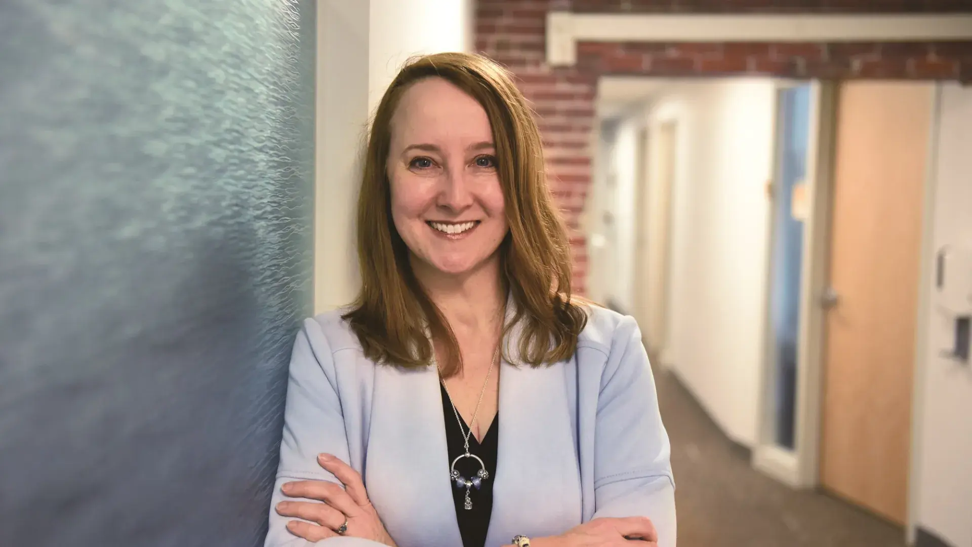 profile photo of kathy, she leans against a brick wall