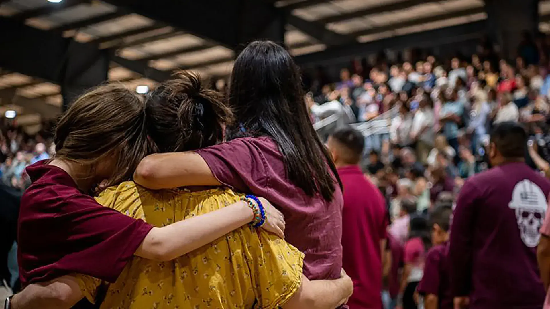 Photo of community members in Uvalde, Texas, embrace each other at a vigil on Wednesday for the 21 victims of the mass shooting at Rob Elementary School. BRANDON BELL/GETTY