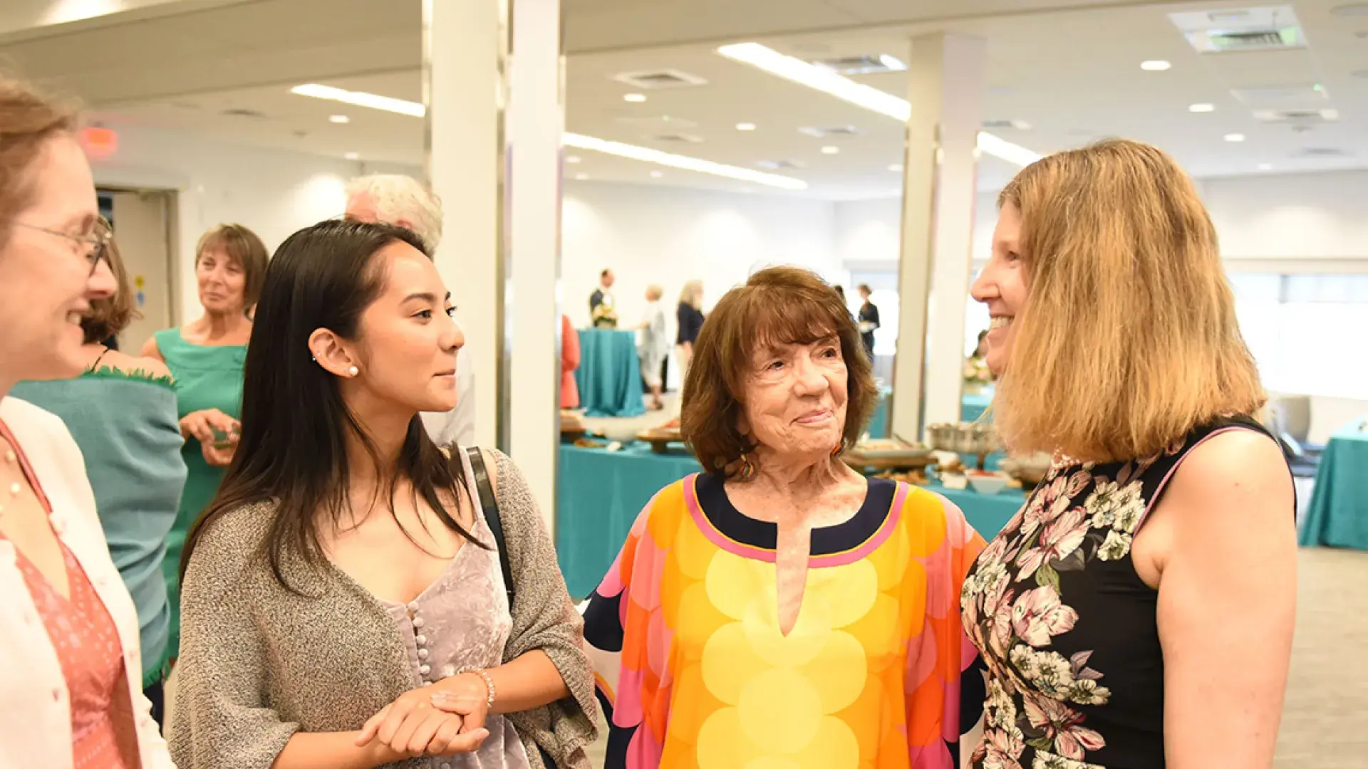 Attendees stand around Julie Atwood at the naming event