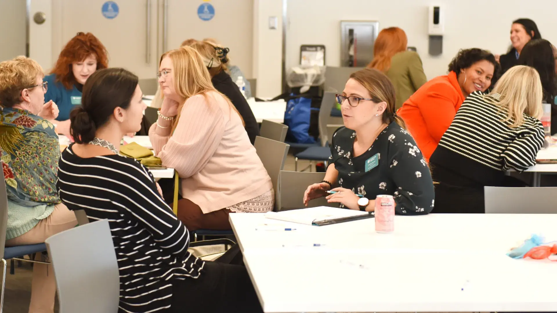 groups of women converse at tables