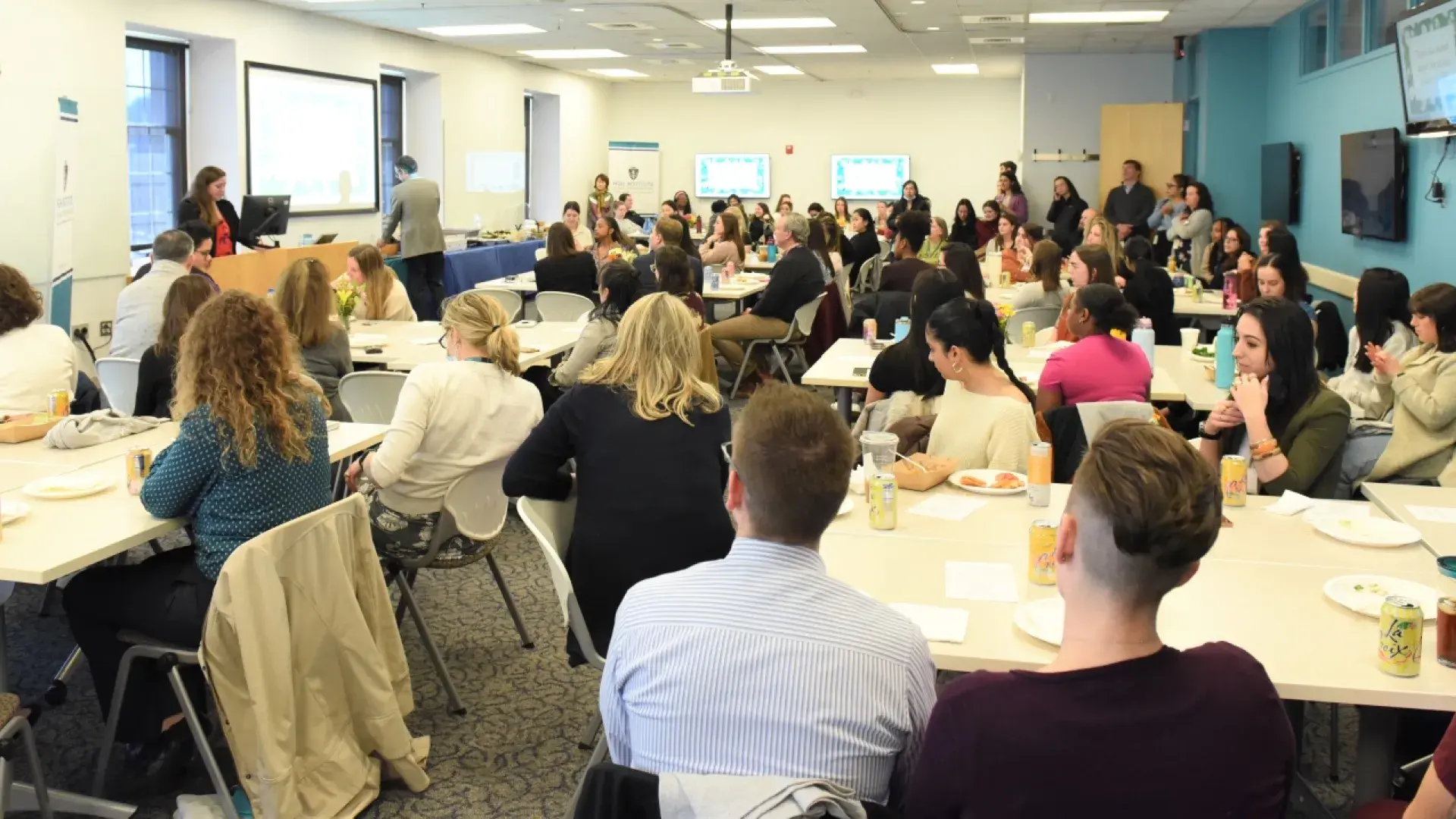 photo of a room with lots of people seated around tables