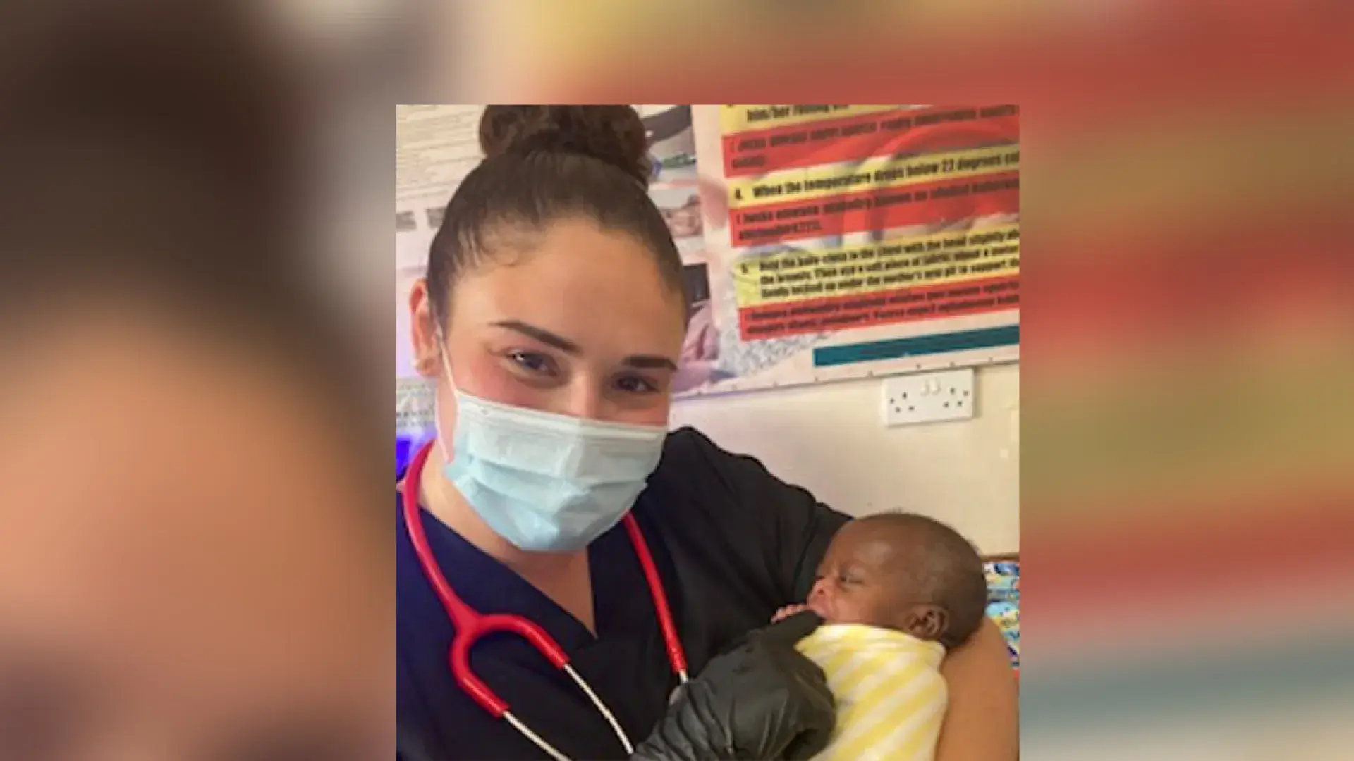 Leah wears a surgical mask and holds a tiny Black baby in her arms