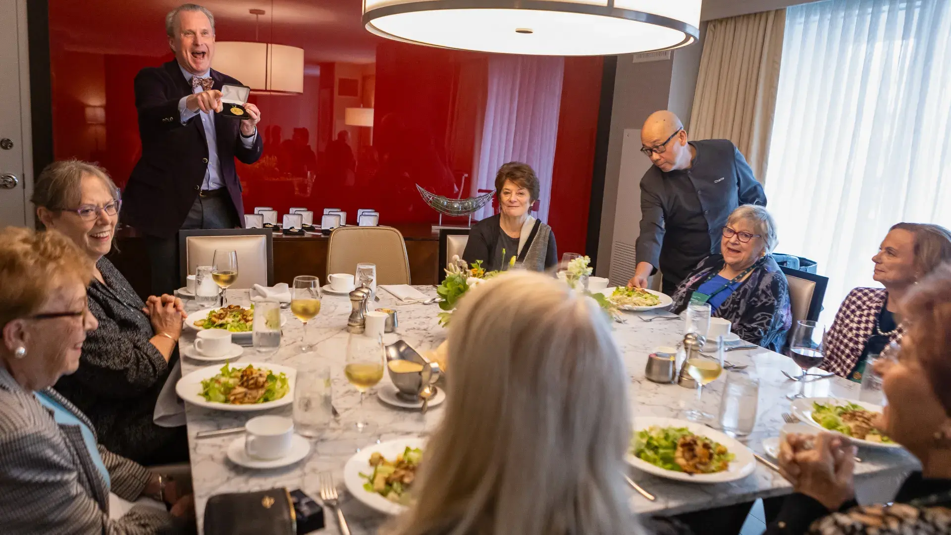 man speaks to a table full of people