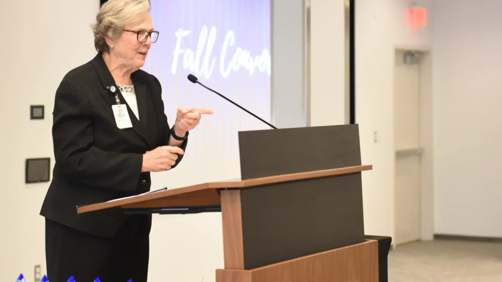 Woman gesturing while talking at a podium