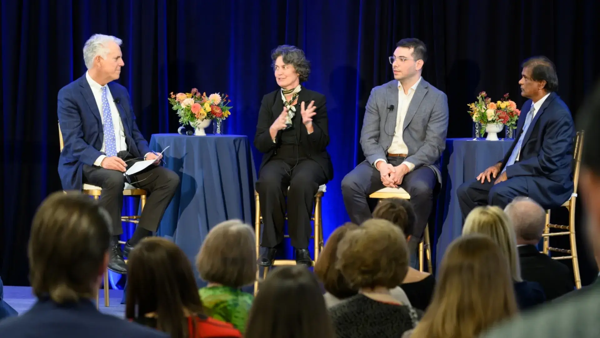 4 people speaking on a stage