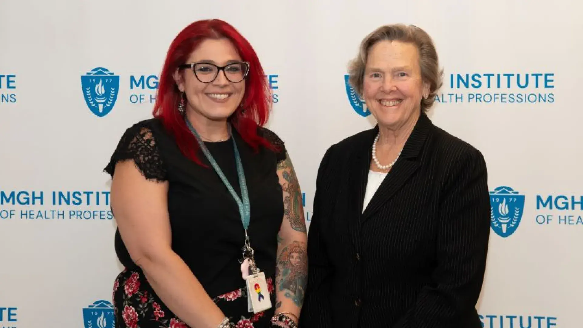 Two women pose and smile