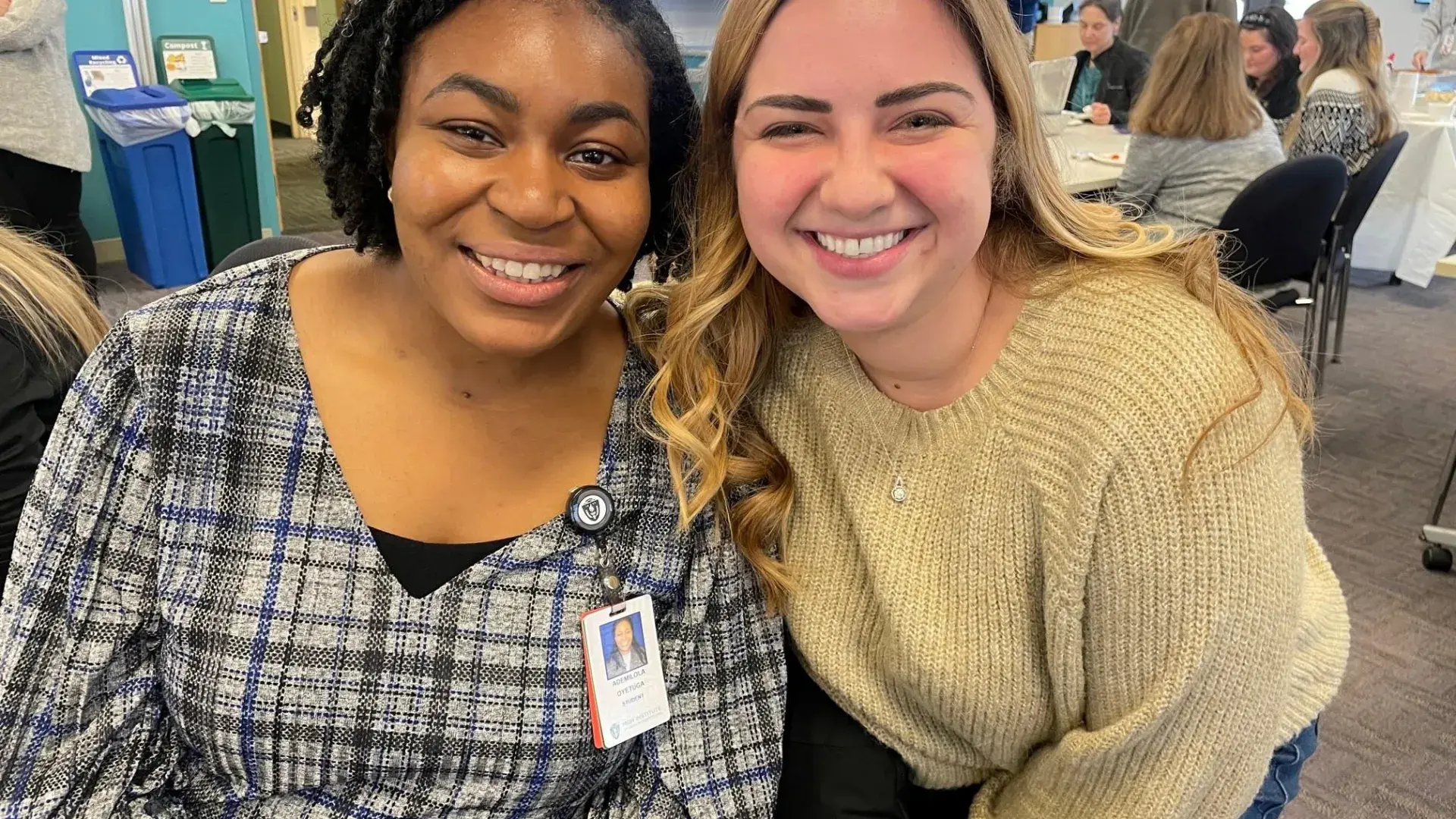 Two MGH IHP DEN nursing students smiling and celebrating the Class of 2025's 100% NCLEX first-time pass rate.