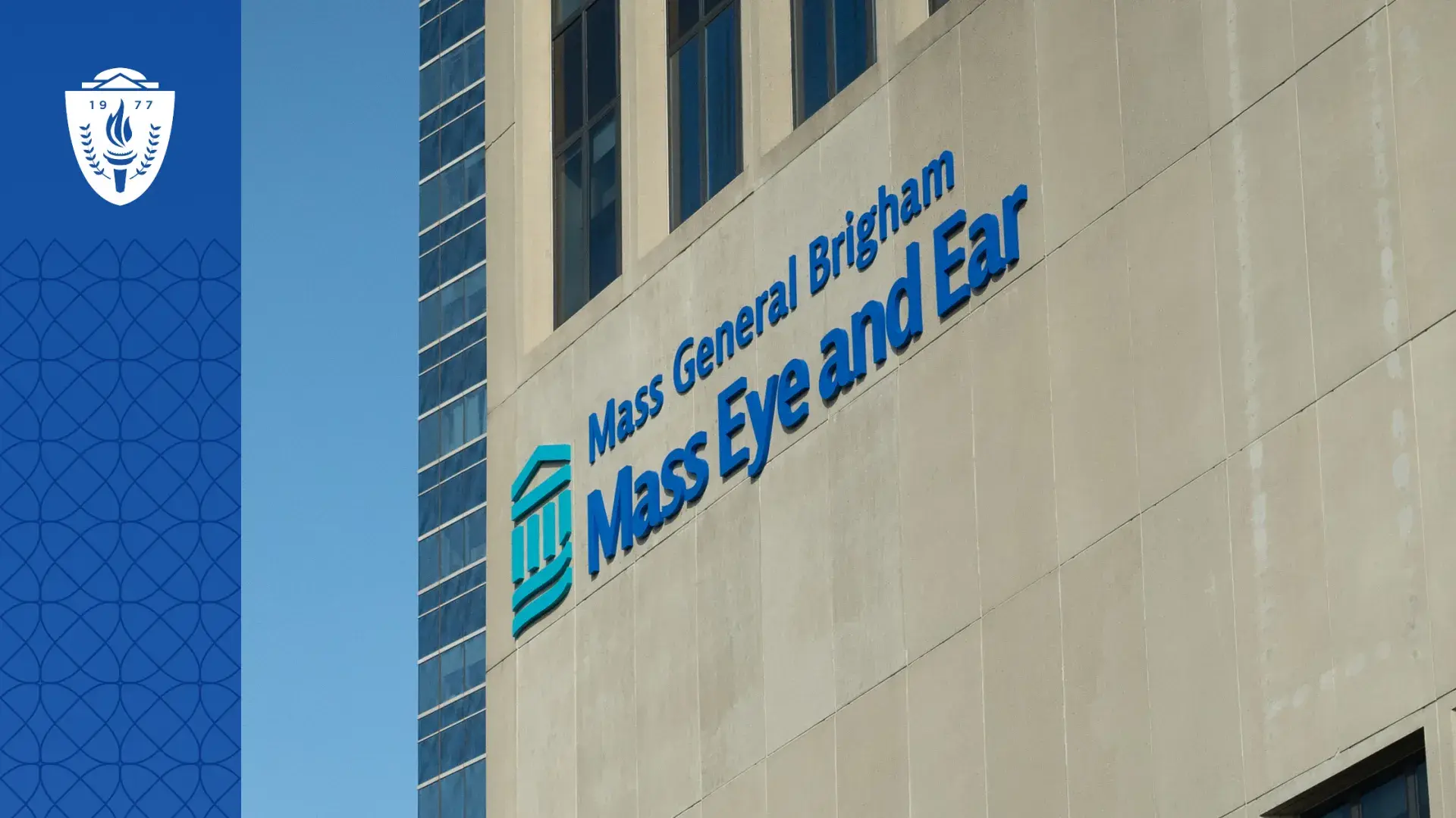 A pale concrete building with the Mass General Brigham logo and words mass eye and ear on the side.