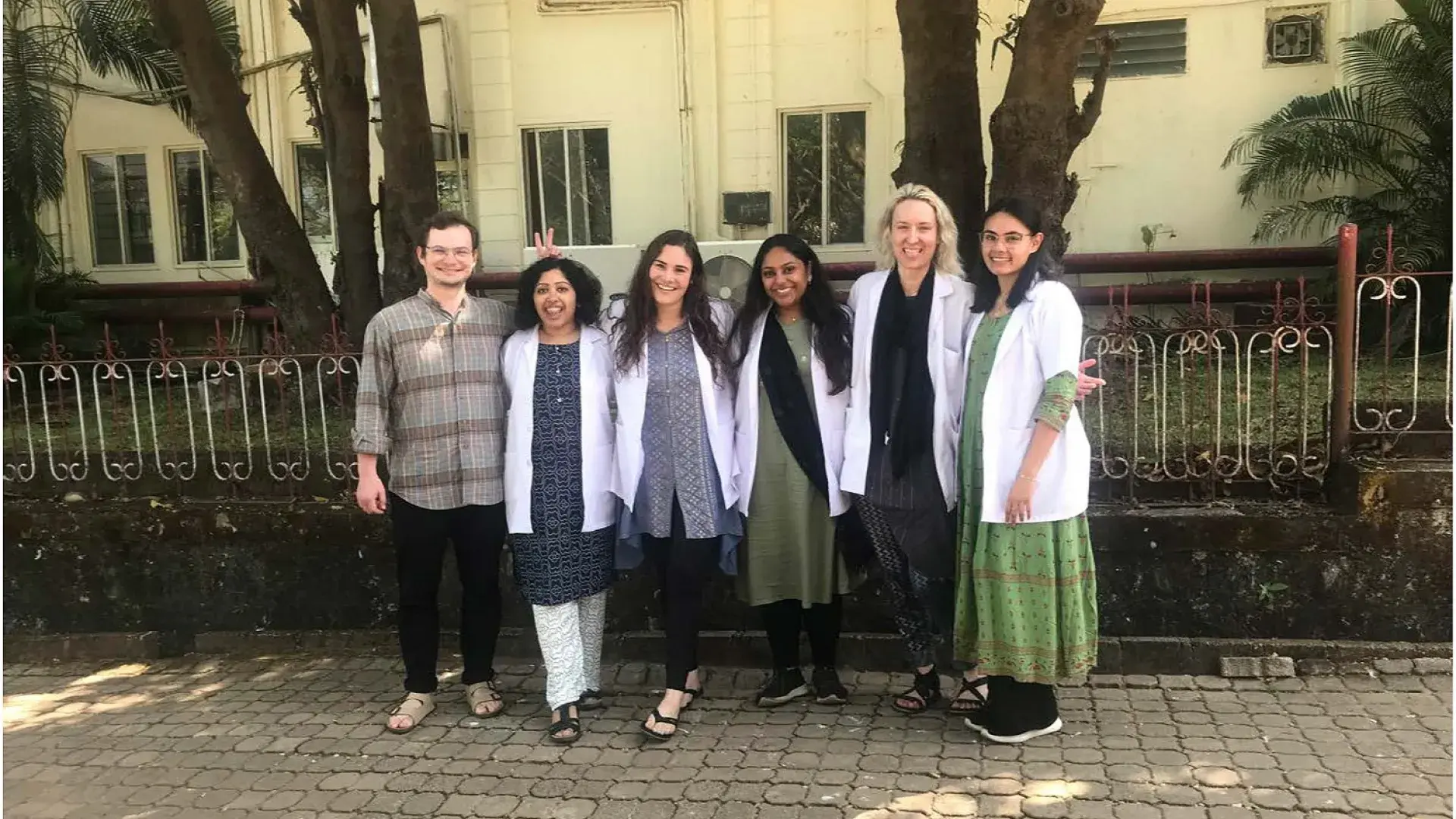 people smile in white medical coats on sidewalk