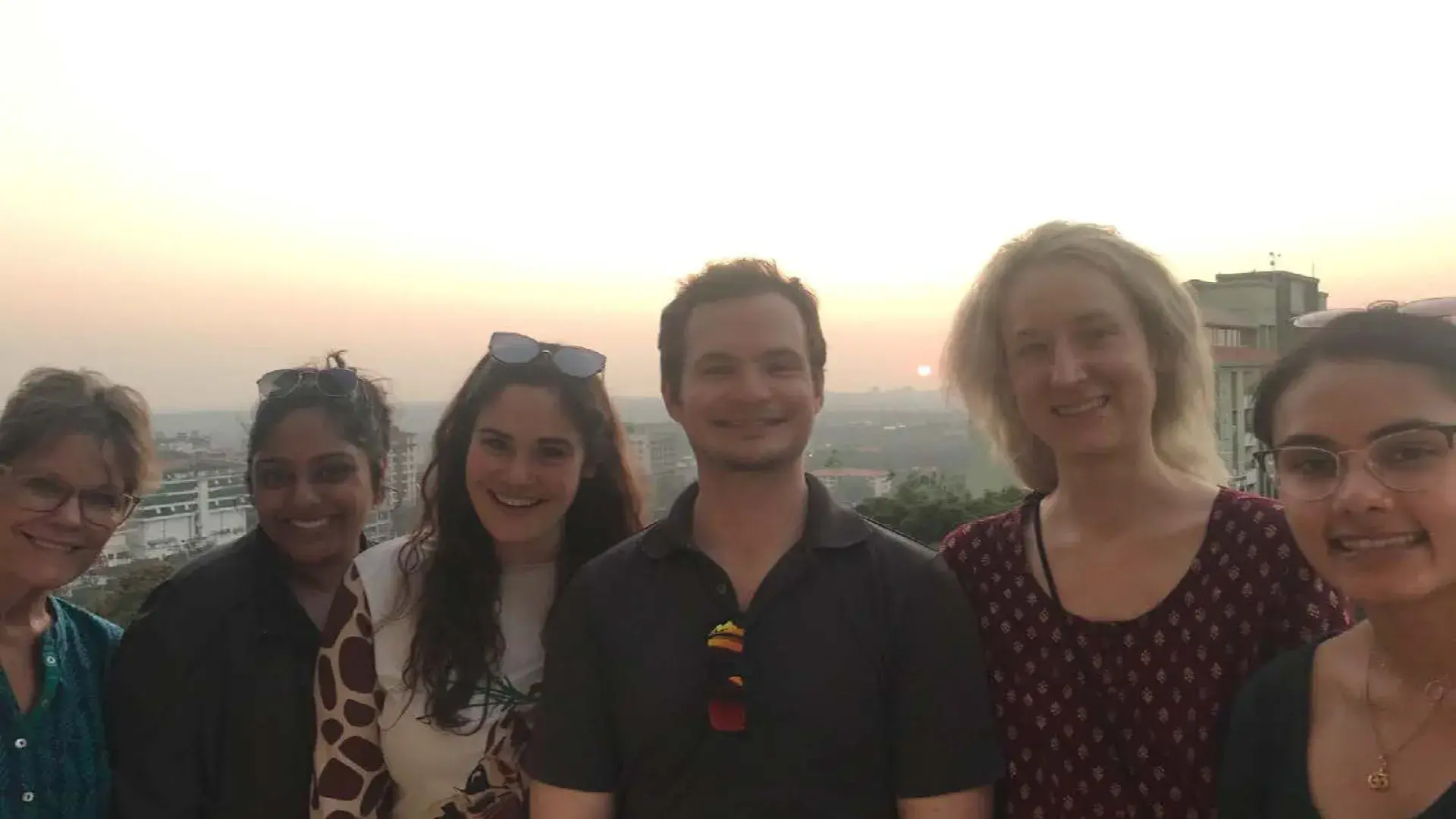 people stand on balcony at sunset