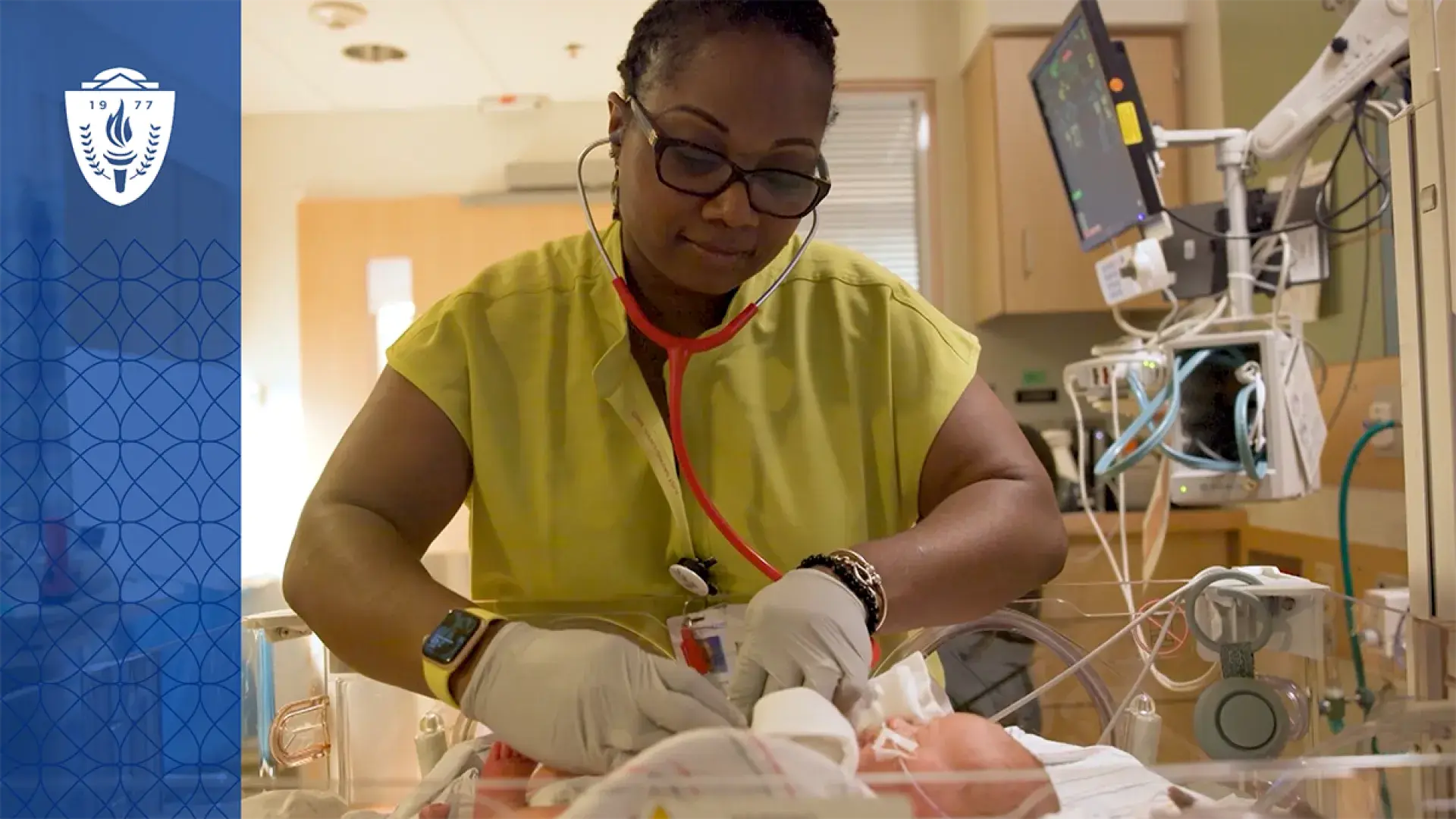 woman uses a stethoscope on a tiny baby in a hospital bassinet 