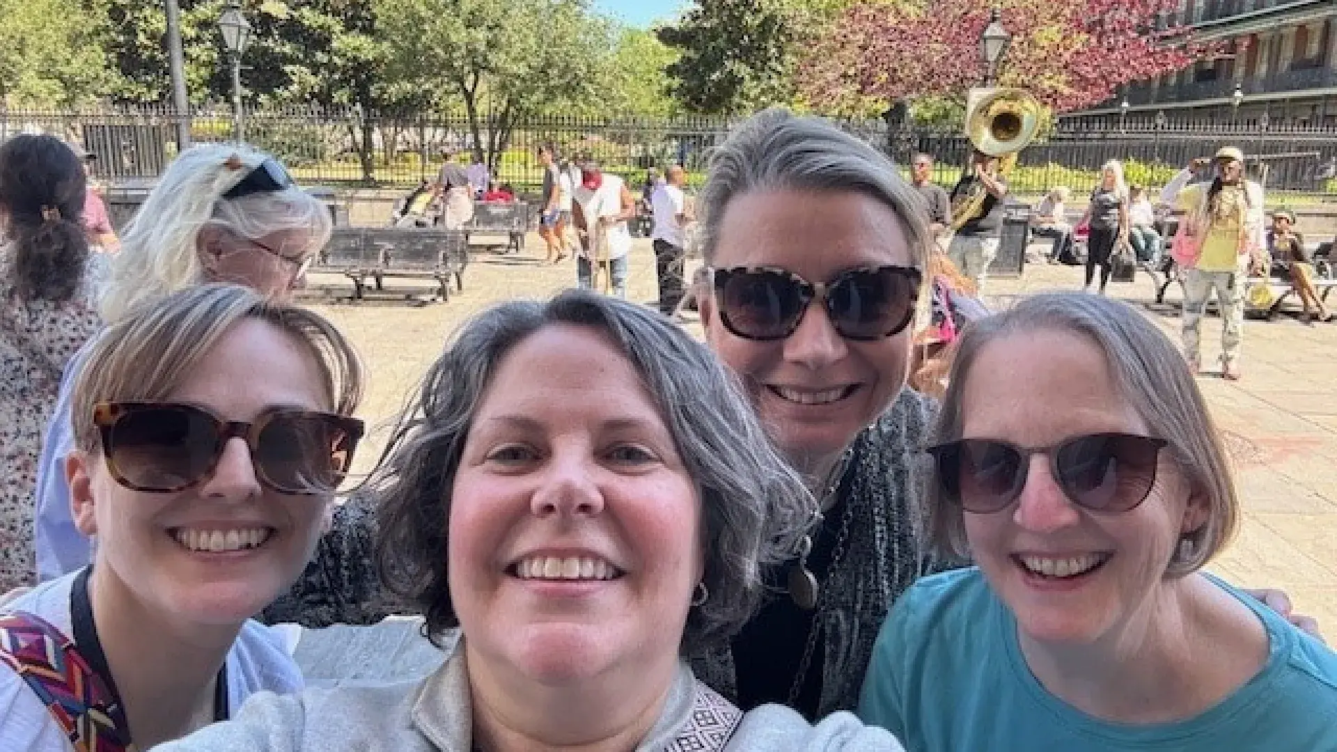 Four women pose for a selfie at an event