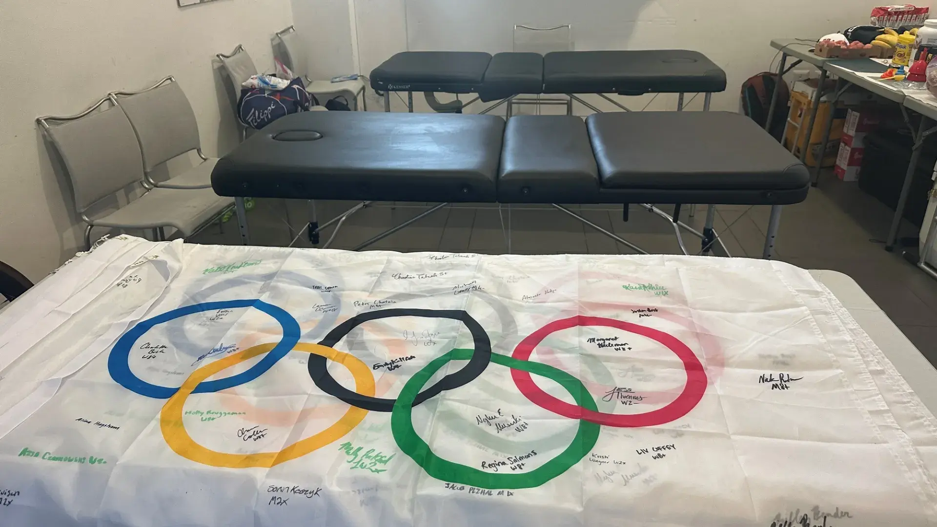 a flag with the olympic rings lays on a desk