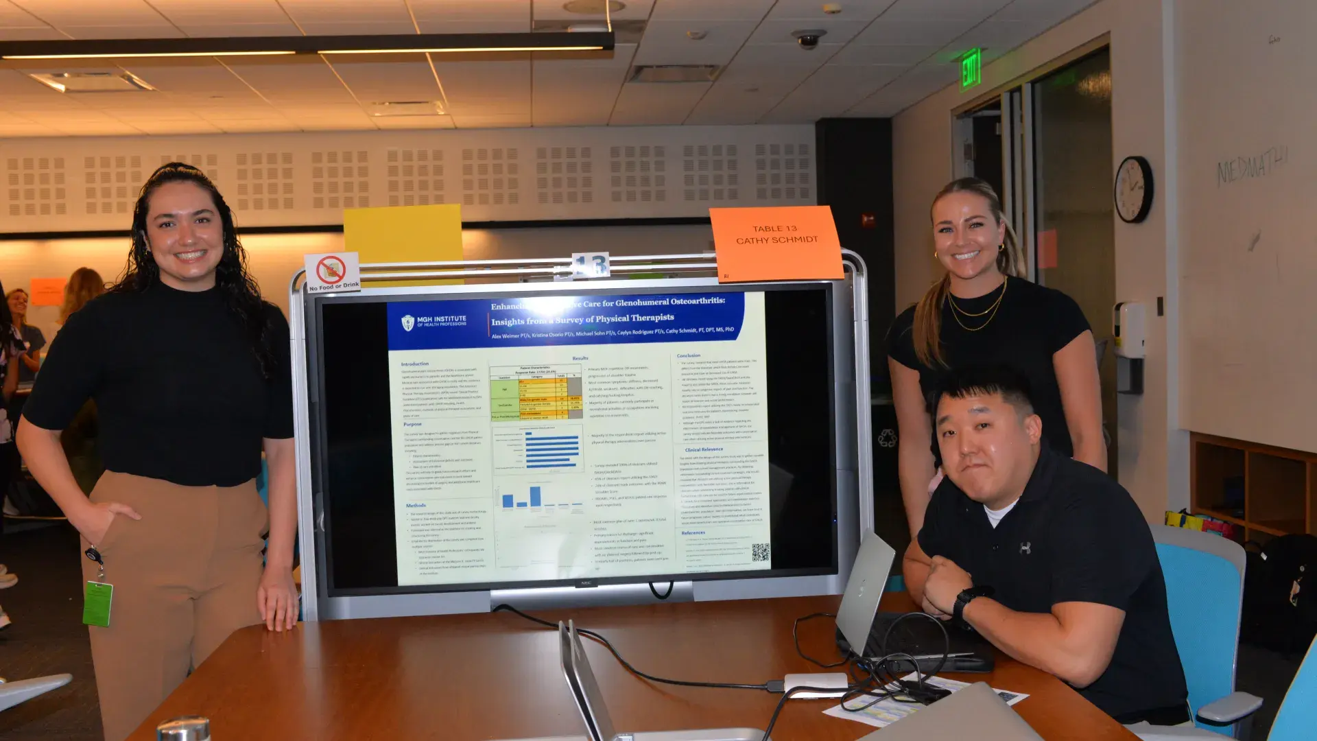 Three people in front of a screen presenting a project