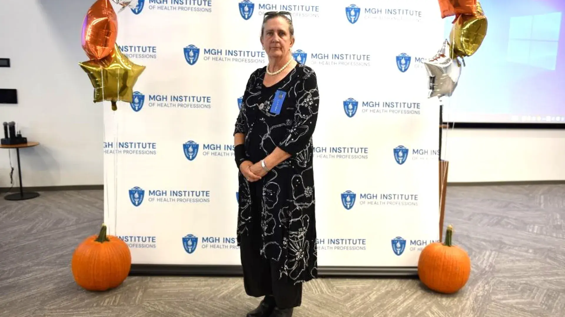 woman stands in front of MGH banner