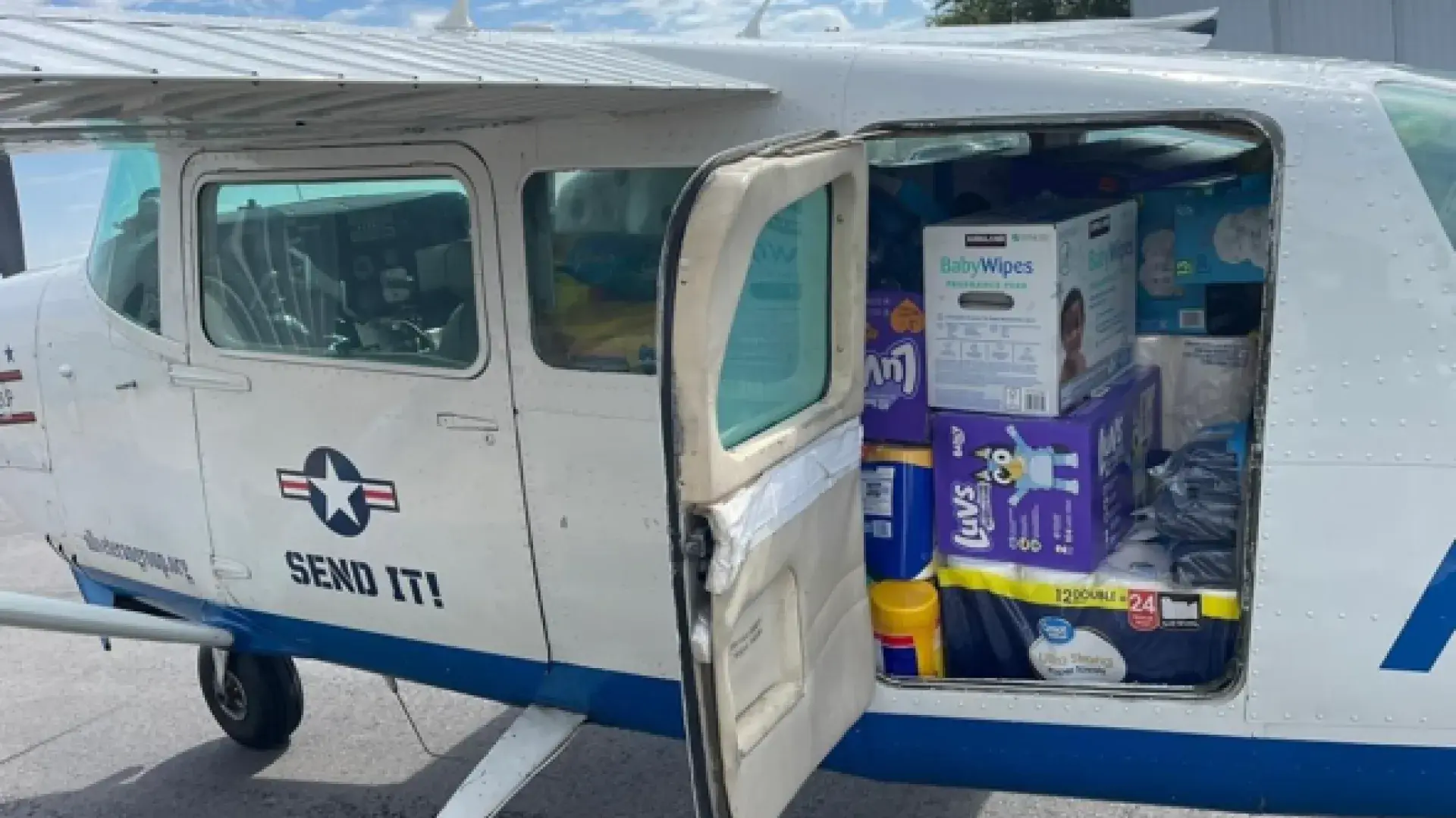 A small airplane full of supplies sits on the ground