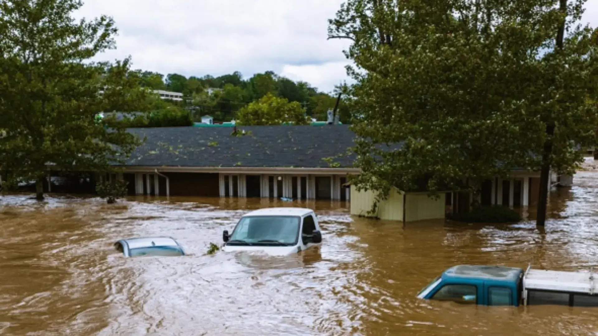 A partially submerged home and cars after a hurricane