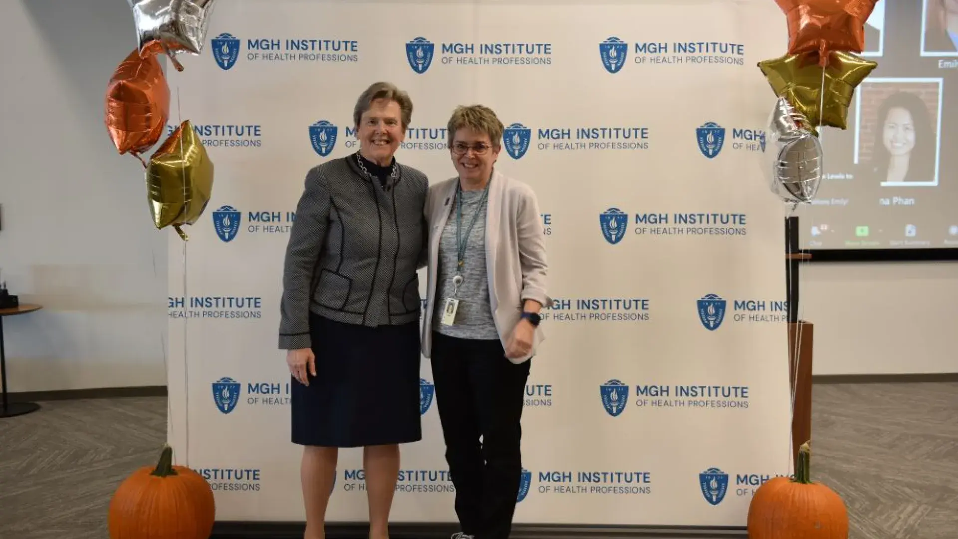 two women stand in front of MGH banner