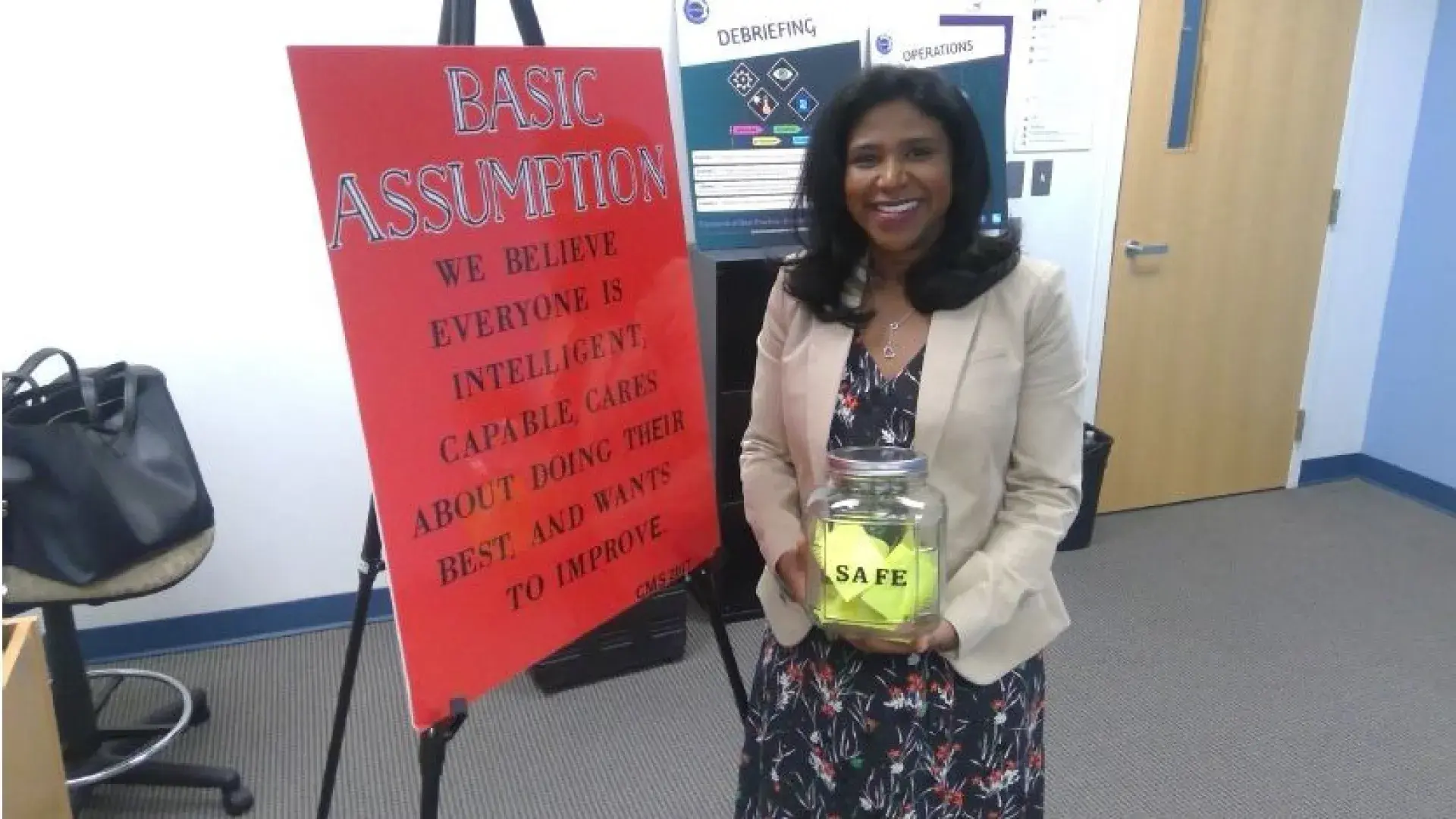 Woman holding a cannister in front of a poster board