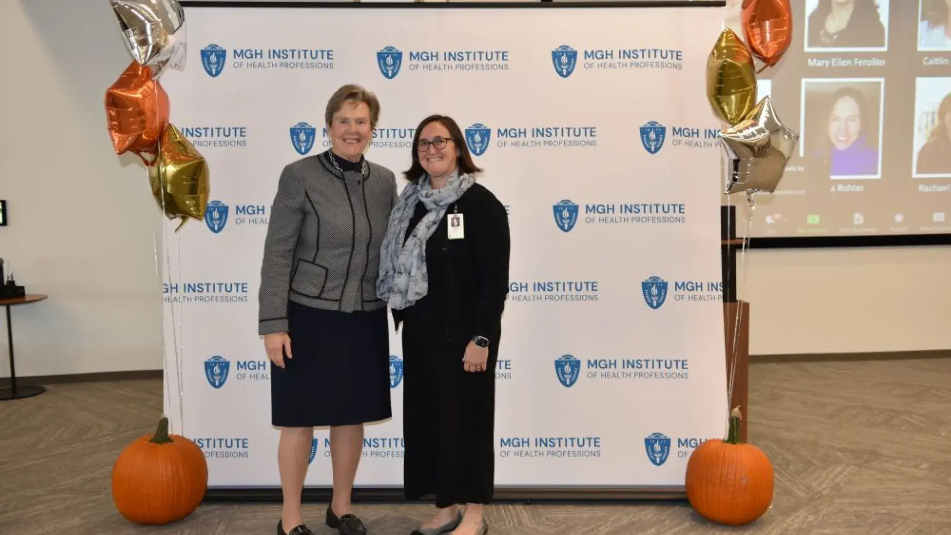 two women stand in front of MGH banner