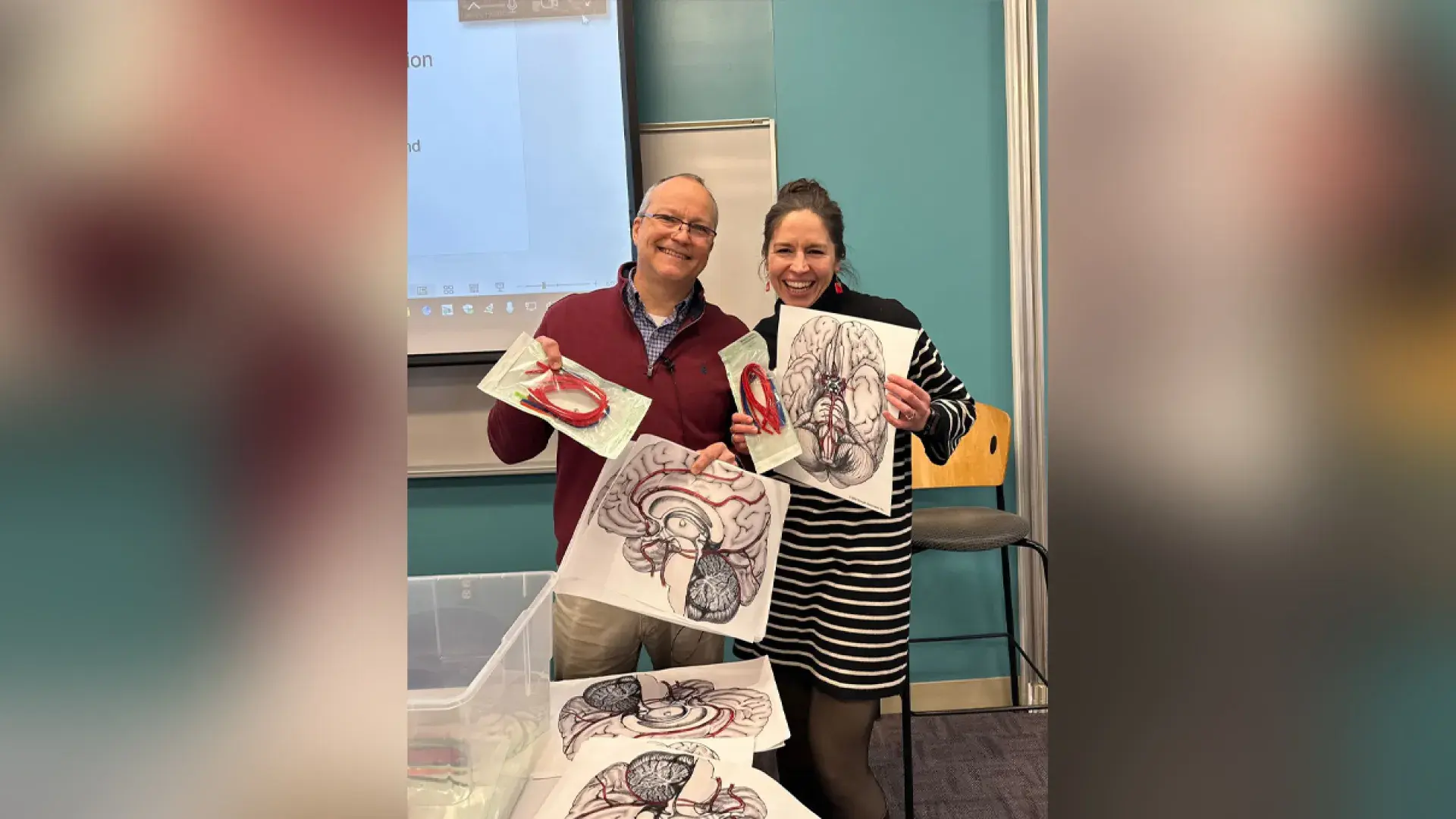 two people holding paper and pipe cleaners