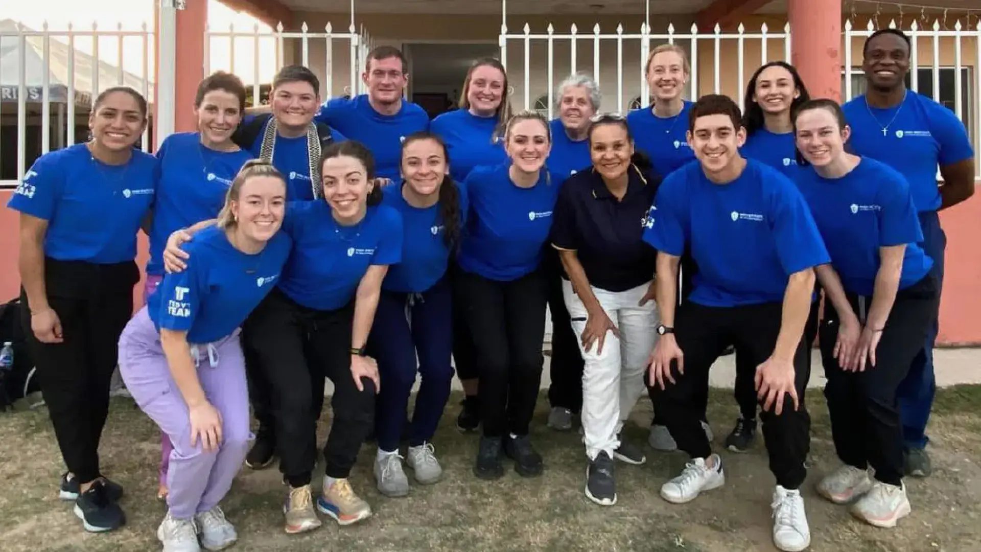 students pose in front of a clinic