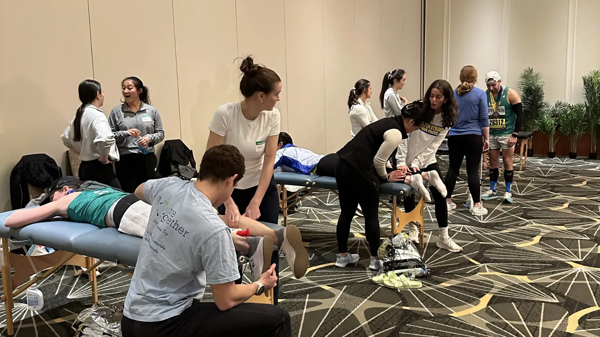 A room with two massage tables and people getting massages