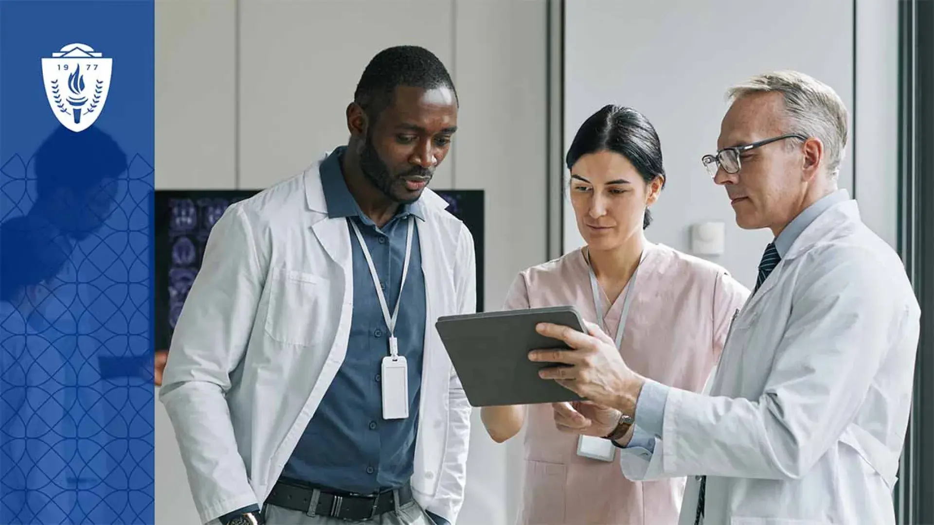 3 health care professionals looking at a tablet.